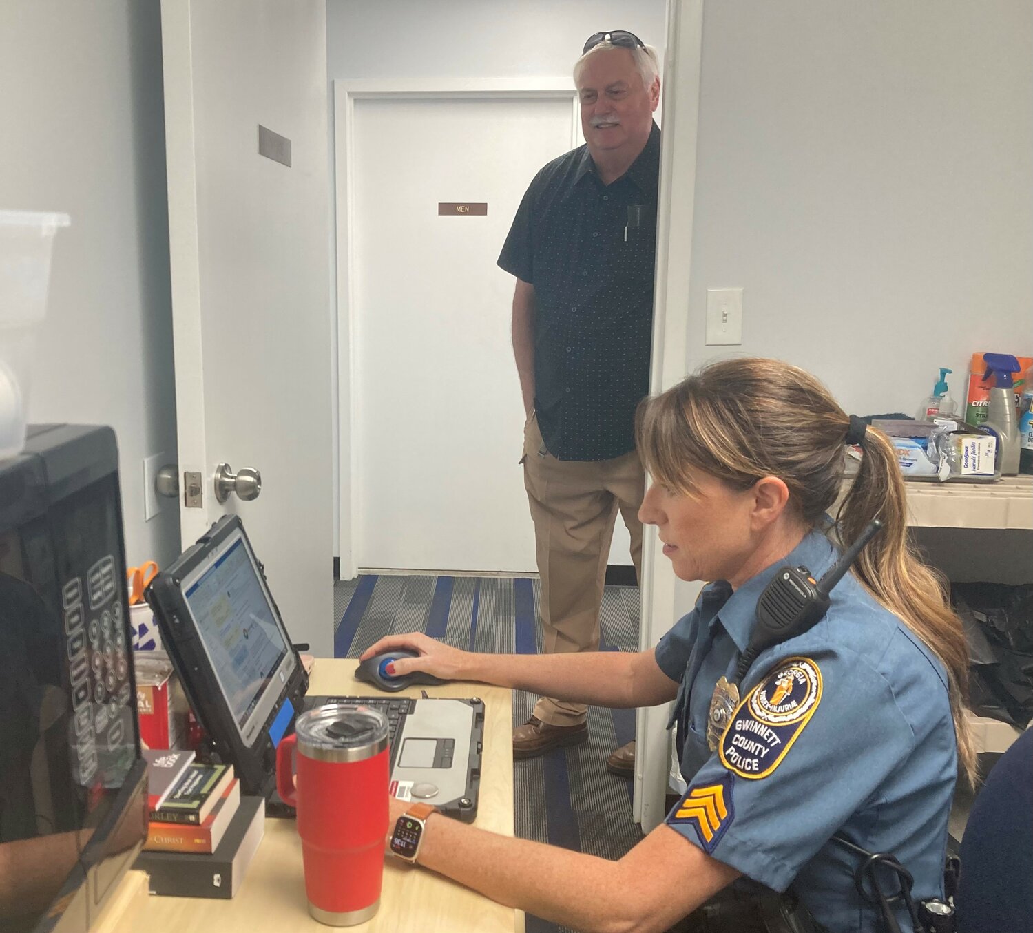Sgt. Michele Pihera tries out a workstation designated for police officers at Bethany Baptist Church in Snellville, Ga. on Monday, September 11, 2023. Executive Pastor Rick Kirkland stands in background.. (Index/Roger Alford)