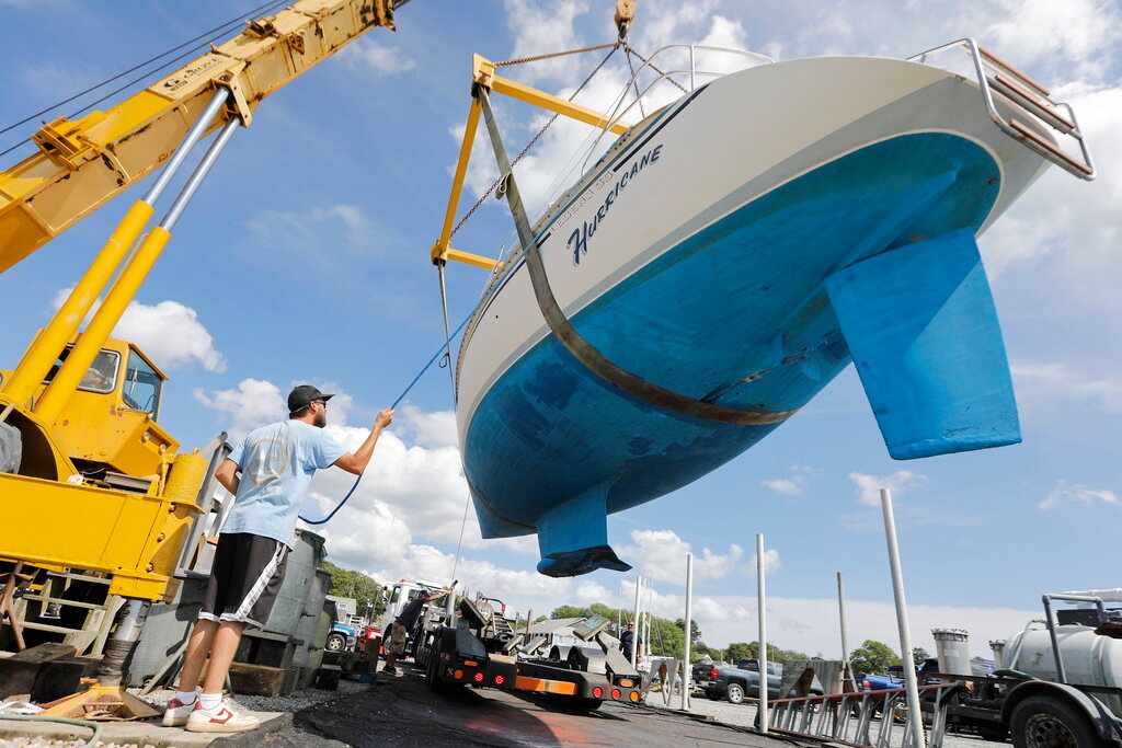 Crews pull a sailboat named Hurricane from the waters of Padanaram Harbor in Dartmouth, Mass., Thursday, Sept. 14, 2023 in preparation for the possible arrival of Hurricane Lee. (Peter Pereira/The Standard-Times via AP)