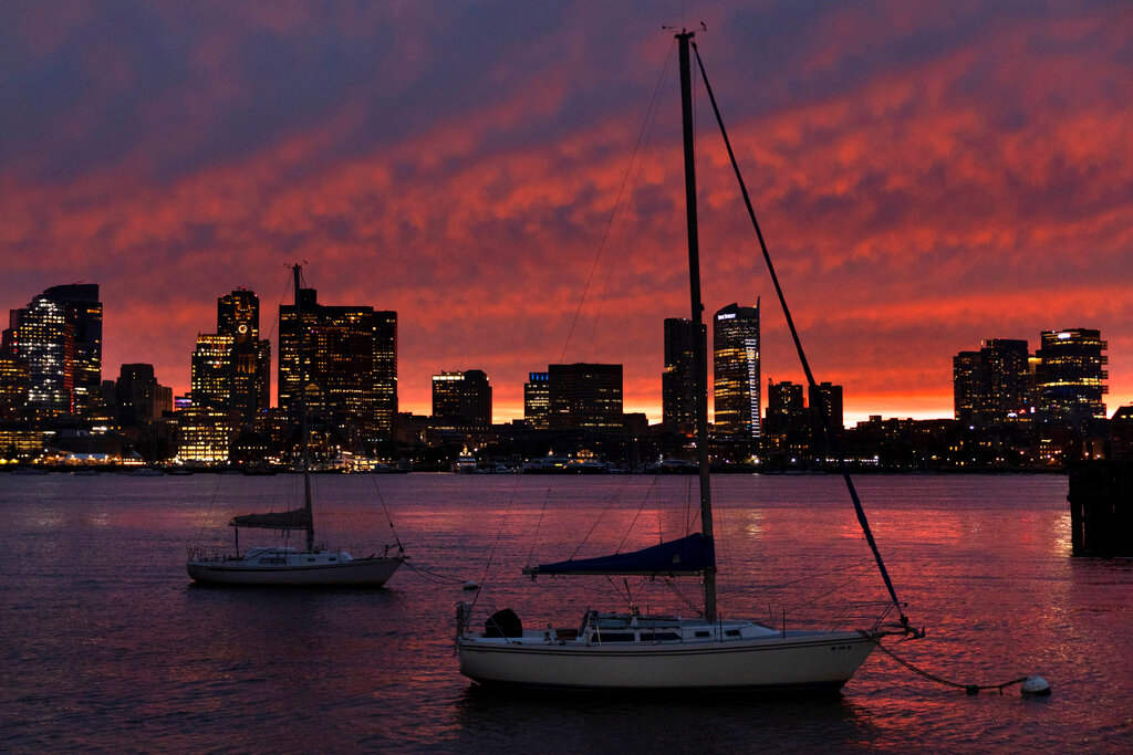 The sun sets behind the city skyline in advance of Hurricane Lee, Friday, Sept. 15, 2023, in Boston. (AP Photo/Michael Dwyer)