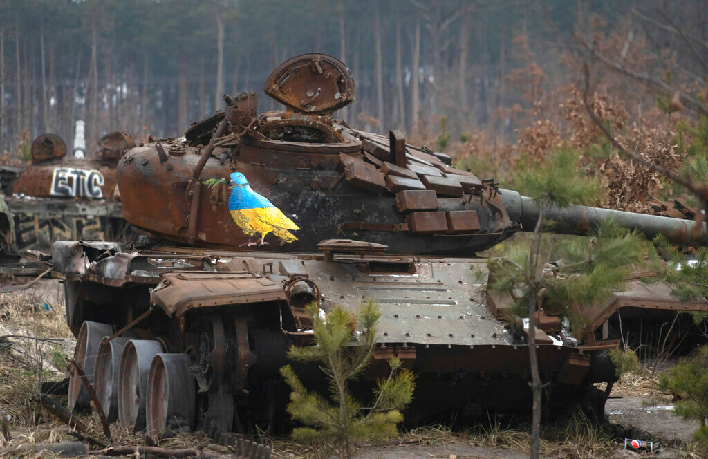 A destroyed Russian tank with artwork depicting a dove with an olive branch by famous street artist TvBoy in the village of Dmytrivka, Ukraine, Jan. 30, 2023. (AP Photo/Efrem Lukatsky, File)
