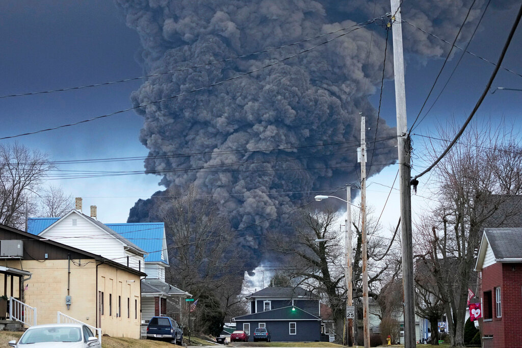 A black plume rises over East Palestine, Ohio, as a result of a controlled detonation of a portion of a derailed Norfolk Southern train Feb. 6, 2023. (AP Photo/Gene J. Puskar, File)