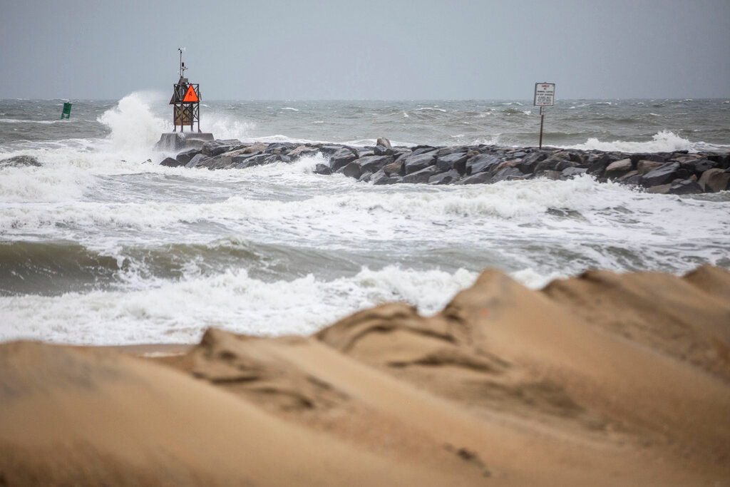 Waves break along the jetty at Rudee Inlet in Virginia Beach, Va., on Friday, Sept. 22, 2023 as Tropical Storm Ophelia approaches the area. (Kendall Warner/The Virginian-Pilot via AP)