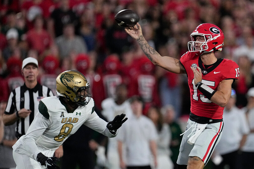 Georgia quarterback Carson Beck (15) throws under pressure from UAB linebacker Desmond Little (8) during the first half of an NCAA college football game, Saturday, Sept. 23, 2023, in Athens, Ga. (AP Photo/John Bazemore)