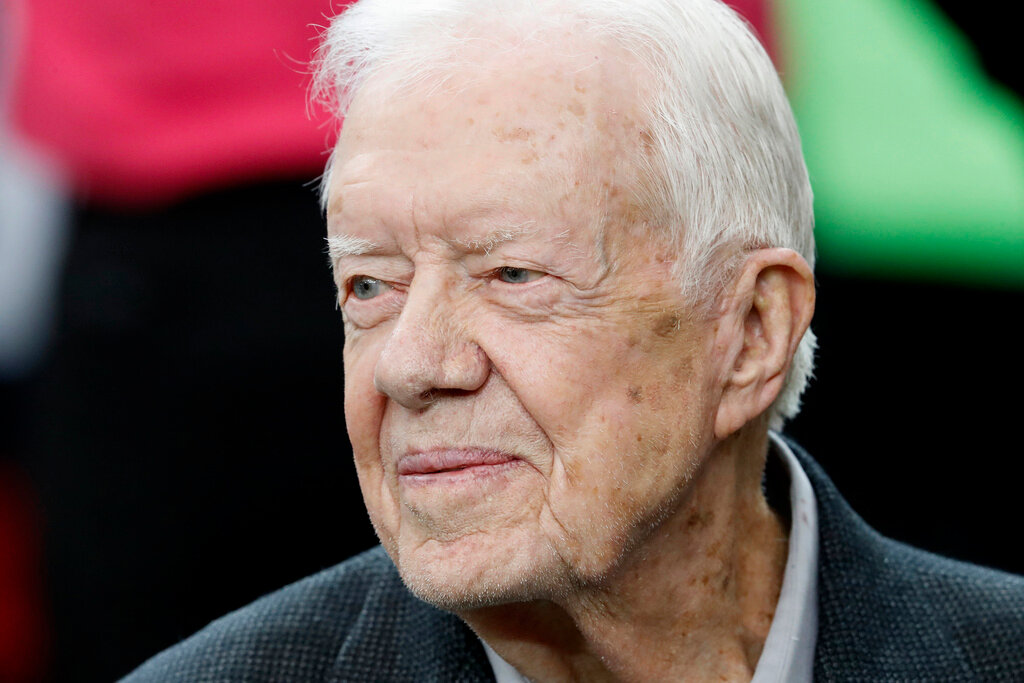 Former President Jimmy Carter sits on the Atlanta Falcons bench before the first half against the San Diego Chargers, Oct. 23, 2016, in Atlanta. (AP Photo/John Bazemore, File)
