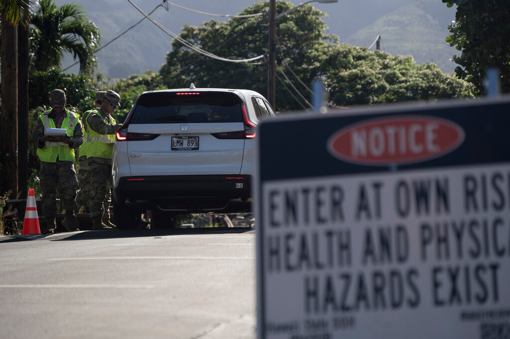 The Hawaii National Guard checks on a car passing the checkpoint on Kaniau Street on Monday, Sept. 25, 2023, in Lahaina, Hawaii. (AP Photo/Mengshin Lin)