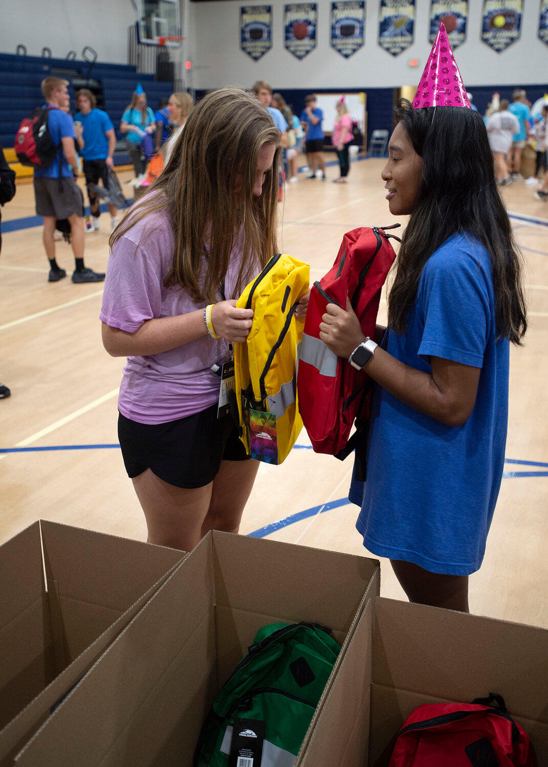 Emily Sinclair, left, and Joshwelle Dela Rama pray over backpacks they just filled at a "Backpack Party" at Confluence 2023 at Eagle's Landing First Baptist Church in McDonough, Ga., Saturday, Sept. 23, 2023. Both are students at Valdosta State. Students filled more than 650 backpacks for Mission Georgia's outreach programs. (Index/Henry Durand)