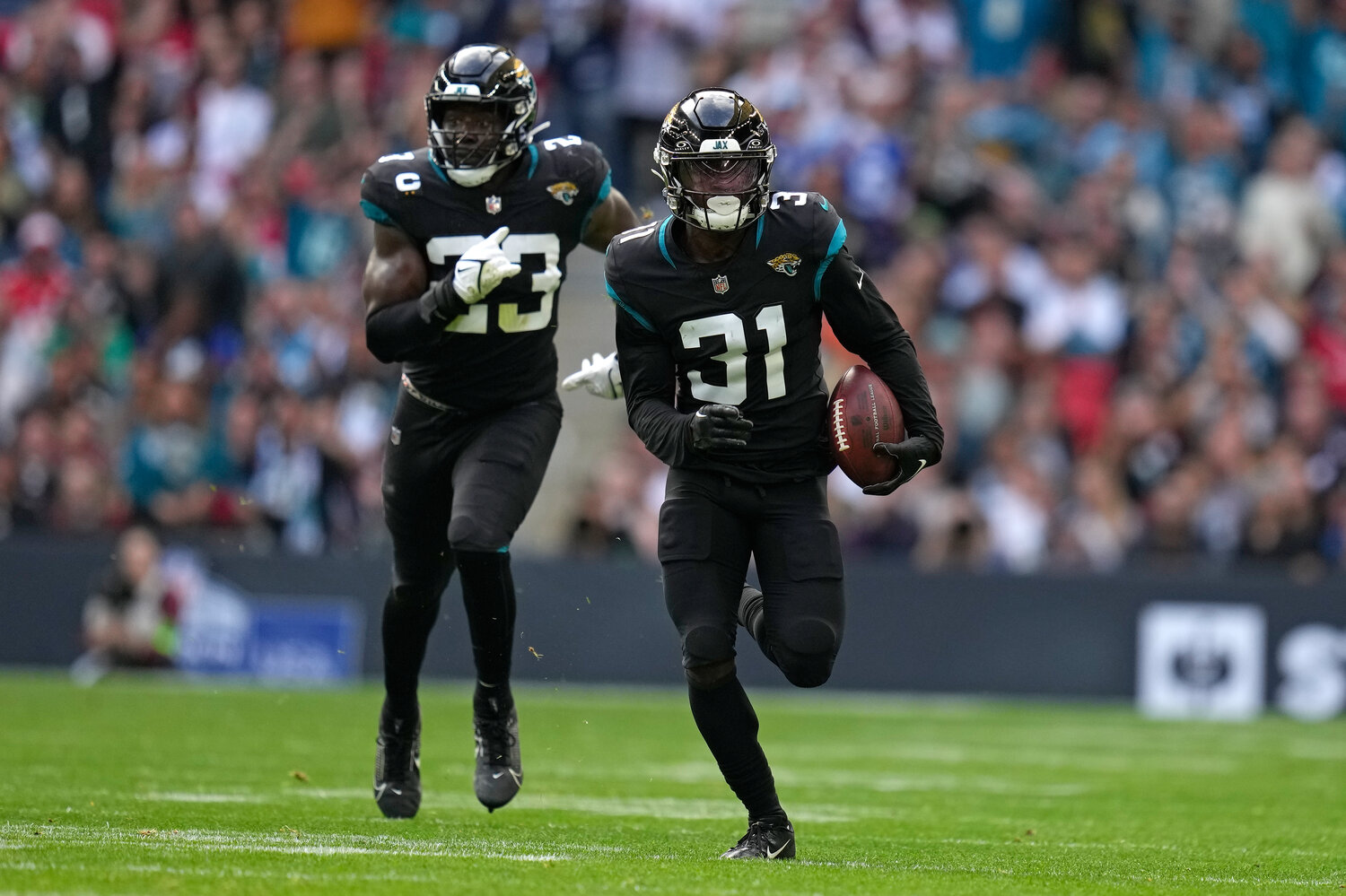 Jacksonville Jaguars cornerback Darious Williams (31) returns an interception for a 61-yard touchdown against the Atlanta Falcons in London, Sunday, Oct. 1, 2023. (AP Photo/Kirsty Wigglesworth)
