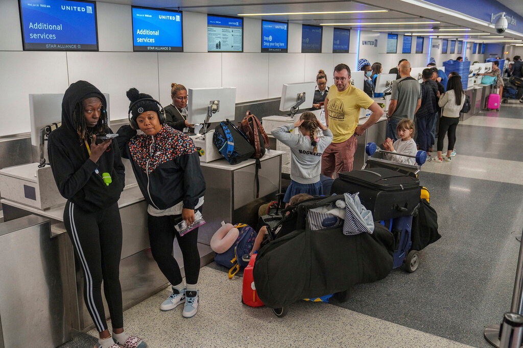 Travelers await at the departure counter at the United Airlines terminal at Los Angeles International Airport, June 28, 2023, in Los Angeles. (AP Photo/Damian Dovarganes, File)