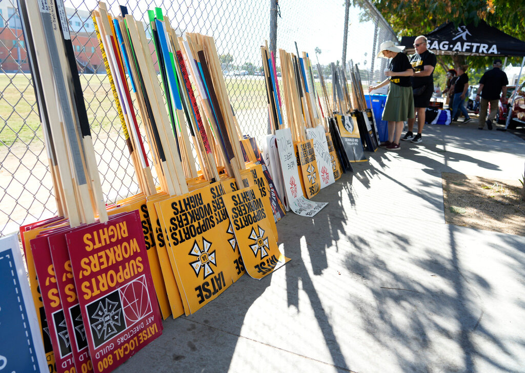 Striking SAG-AFTRA members pick out signs for a picket line outside Netflix studios Wednesday, Nov. 8, 2023, in Los Angeles. (AP Photo/Chris Pizzello)
