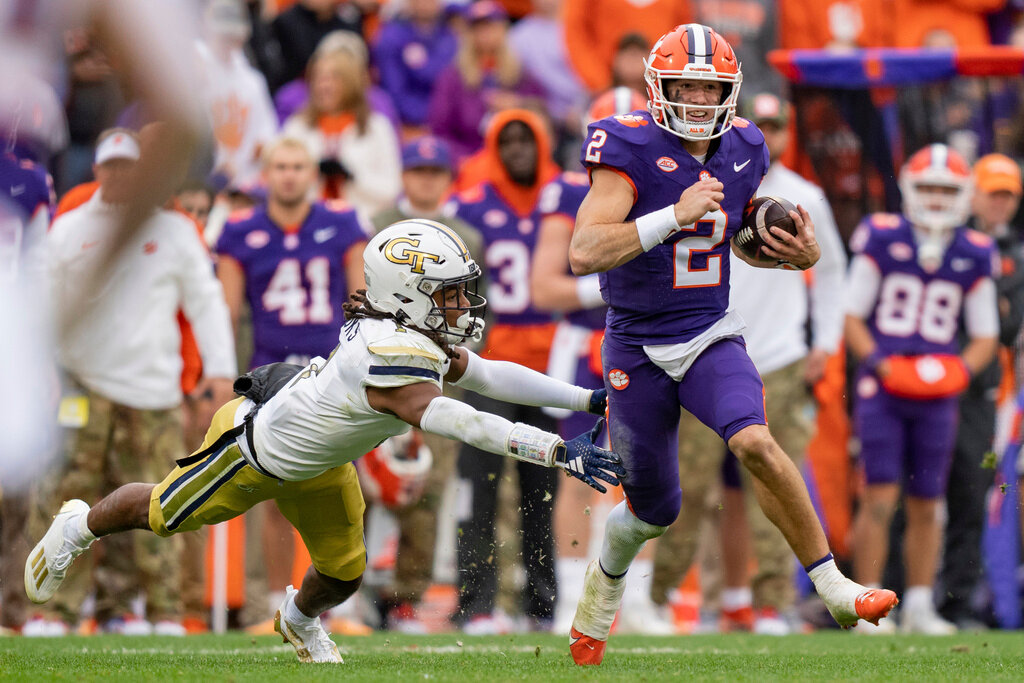 Clemson quarterback Cade Klubnik (2) breaks a tackle from Georgia Tech defensive back LaMiles Brooks (1) during the first half of an NCAA college football game Saturday, Nov. 11, 2023, in Clemson, S.C. (AP Photo/Jacob Kupferman)