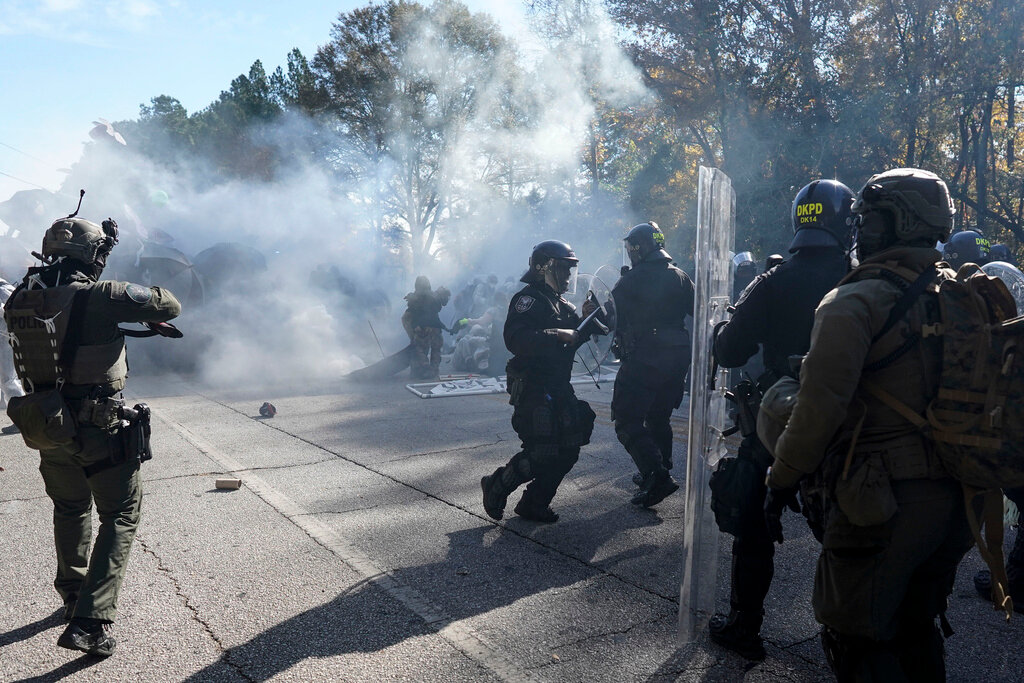 Police disperse a crowd of protesters with gas during a demonstration in opposition to a new police training center, Monday, Nov. 13, 2023, in Atlanta. (AP Photo/Mike Stewart)