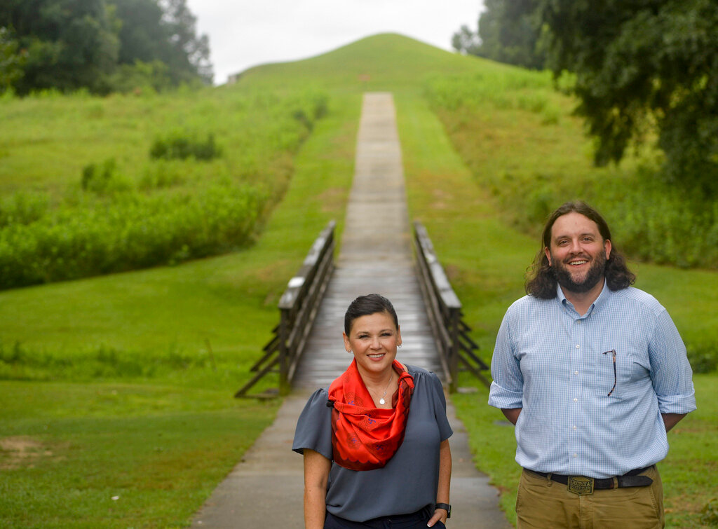 Tracie Revis, left, a citizen of the Muscogee Creek Nation, and Seth Clark, mayor pro-tem of Macon, stand near the Earth Lodge, where Native Americans met for 1,000 years until their forced removal in the 1820s, on Aug. 22, 2022, in Macon, Ga. (AP Photo/Sharon Johnson, File)