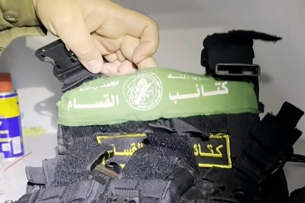In this image taken from a video released by the Israeli Defense Forces, Wednesday, Nov. 15, 2023, Lt. Col. Jonathan Conricus, an Israeli military spokesman, holds up a bullet proof vest with a Hamas insignia that was found along with weapons in a medical closet at the MRI center at al-Shifa hospital in Gaza City. (Israel Defense Forces via AP)