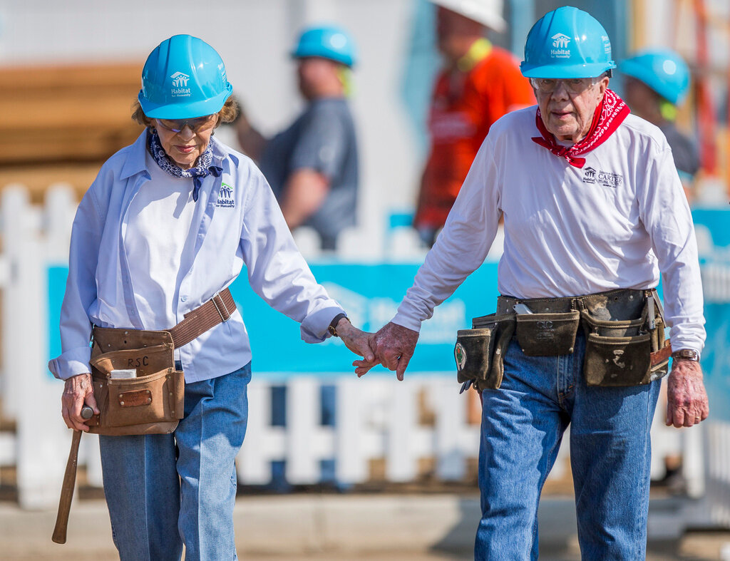 Former President Jimmy Carter, right, holds hands with his wife, former first lady Rosalynn Carter, as they work with other volunteers on site, Aug. 27, 2018, in Mishawaka, Ind. Rosalynn Carter, the closest adviser to Jimmy Carter during his one term as U.S. president and their four decades thereafter as global humanitarians, died Sunday, Nov. 19, 2023. She was 96. (Robert Franklin/South Bend Tribune via AP, File)