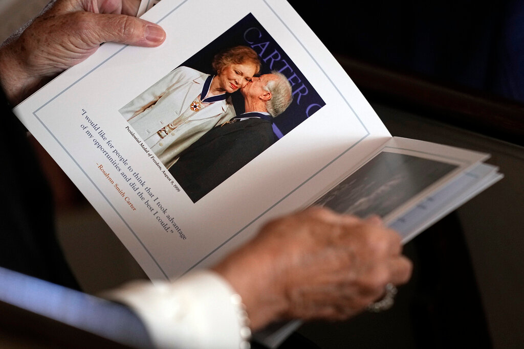 A guest looks at the program before a tribute service for former first lady Rosalynn Carter at Glenn Memorial Church at Emory University on Tuesday, Nov. 28, 2023, in Atlanta. (AP Photo/Brynn Anderson, Pool)