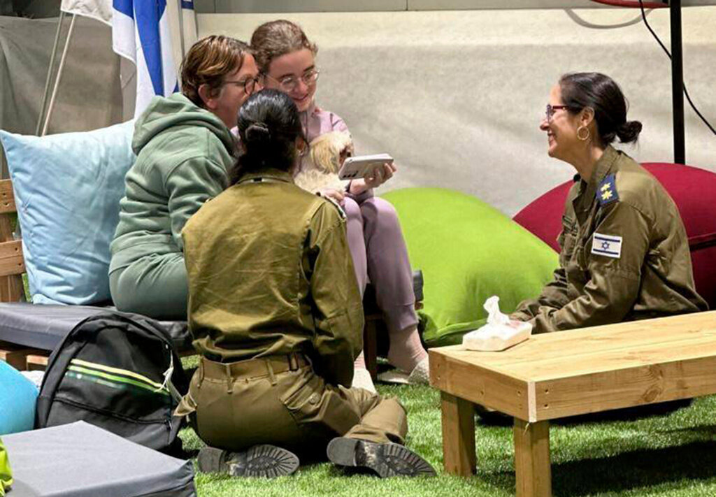 Gabriela and Mia Leimberg, rear, talking with family from a meeting point in Israeli territory after being released by Hamas, Tuesday, Nov. 28, 2023. (GPO/Handout via AP)