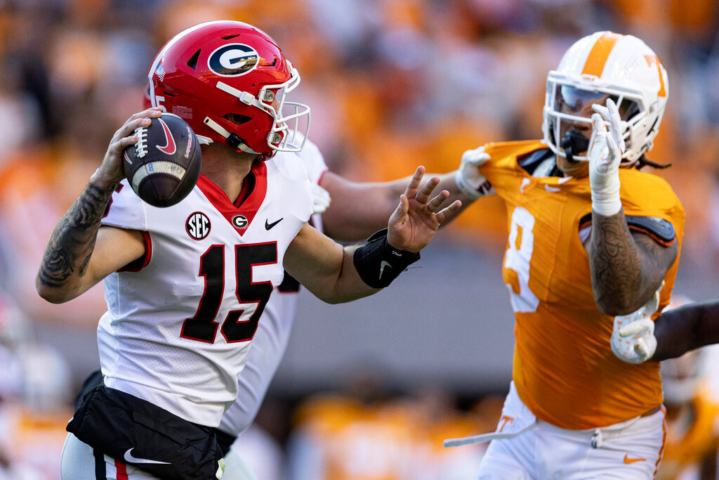 Georgia quarterback Carson Beck (15) throws to a receiver as he's pressured by Tennessee defensive back Brandon Turnage (8) during the first half Nov. 18, 2023, in Knoxville, Tenn. (AP Photo/Wade Payne, File)