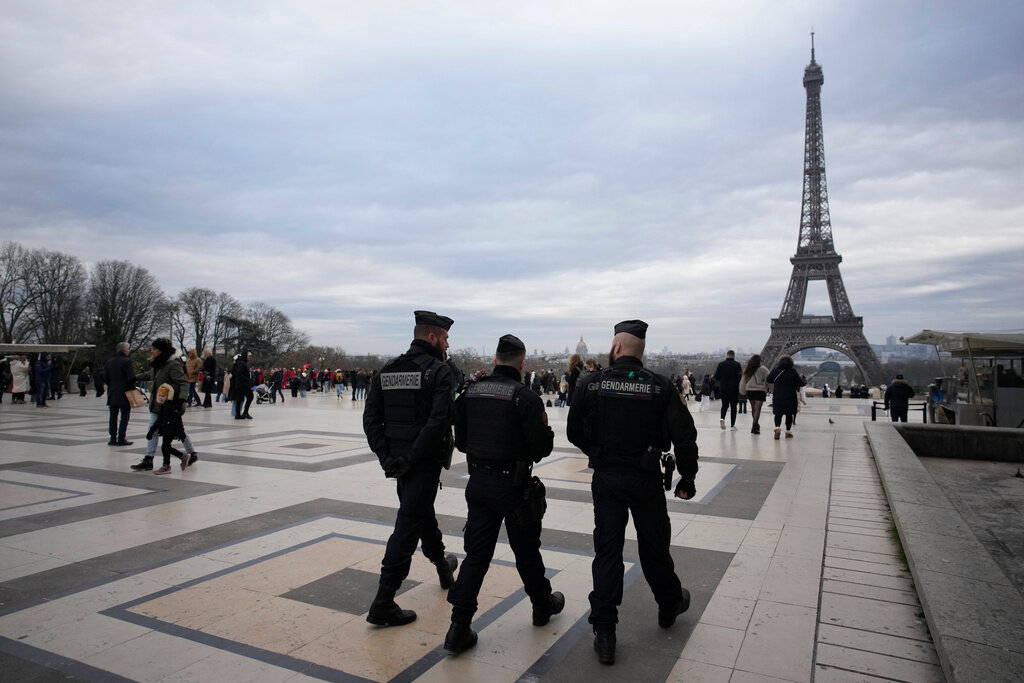 French gendarmes patrol the Trocadero plaza near the Eiffel Tower after a man killed a German tourist with a knife Sunday, Dec. 3, 2023. (AP Photo/Christophe Ena)