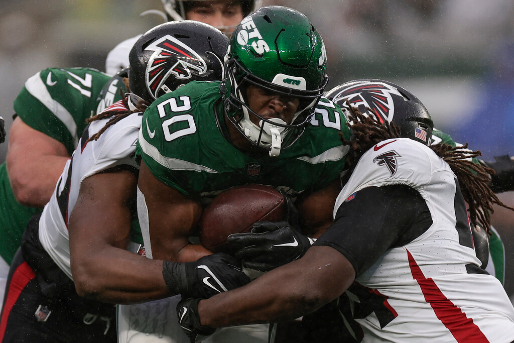 New York Jets running back Breece Hall (20) is tackled by Atlanta Falcons defenders in the second quarter Sunday, Dec. 3, 2023, in East Rutherford, N.J. (AP Photo/Adam Hunger)