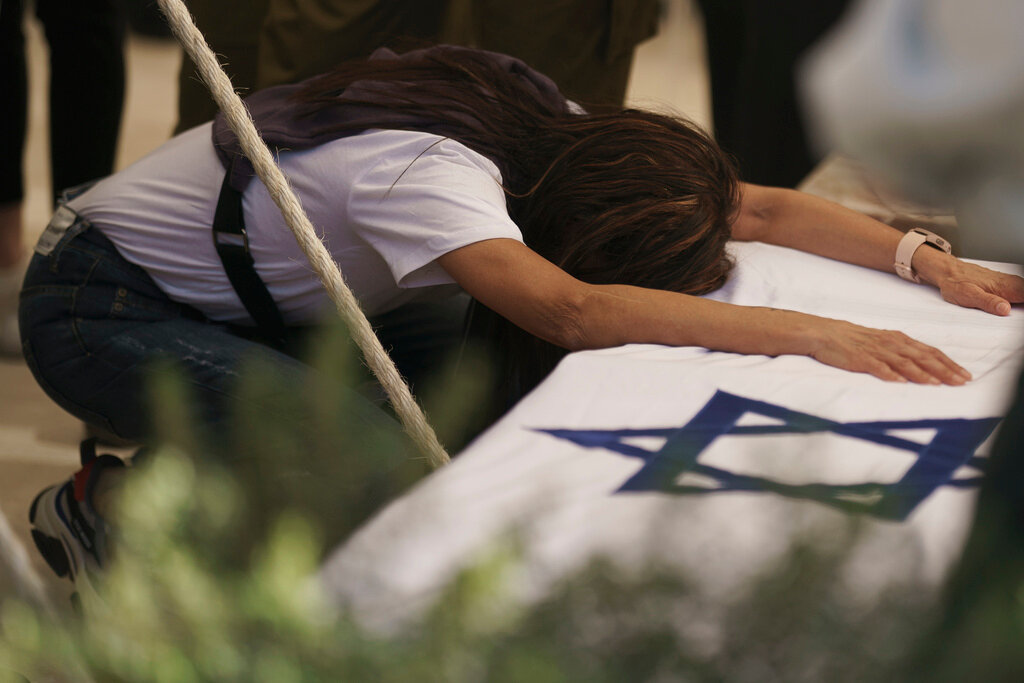 Mother of Israeli Col. Asaf Hamami mourns during his funeral at the Kiryat Shaul military cemetery, in Tel Aviv, Israel, Monday, Dec. 4, 2023. Hamami, the commander of the Gaza Division's Southern Brigade, was killed on Oct. 7, in the attack on Israel by the militant group Hamas, and his remains are being held in the Gaza Strip, the Israeli military said. (AP Photo/Leo Correa)