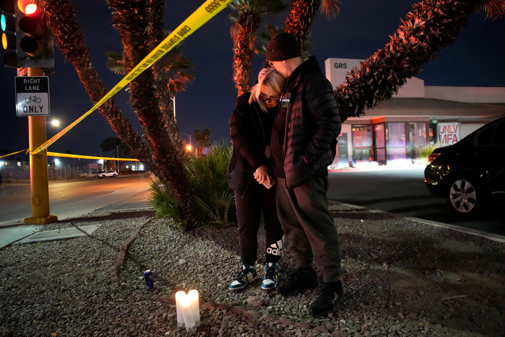 Sean Hathcock, right, kisses Michelle Ashley after the two left candles for victims of a shooting at the University of Nevada, Las Vegas, Wednesday, Dec. 6, 2023, in Las Vegas. (AP Photo/John Locher)