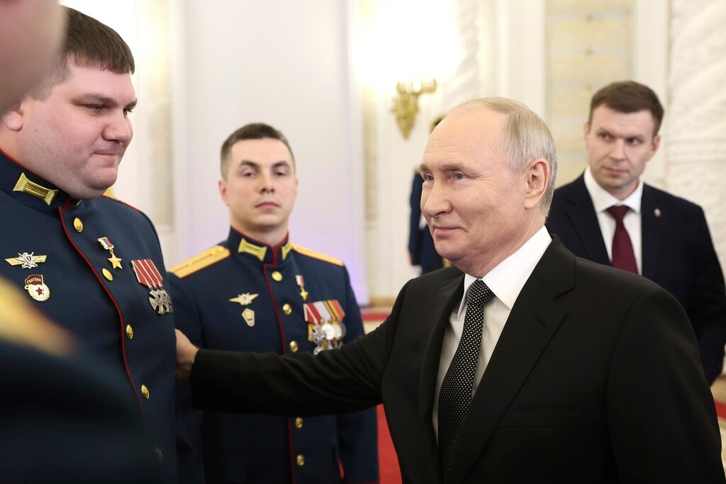 Russian President Vladimir Putin talks with Russian servicemen after they received Gold Star medals to Heroes of Russia in Moscow, Russia, Friday, Dec. 8, 2023. (Valery Sharifulin, Sputnik, Kremlin Pool Photo via AP)