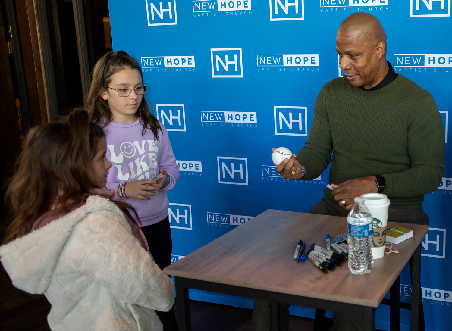 Darryl Strawberry signs a baseball for pair of young fans at New Hope Baptist Church in Fayetteville, Ga., Saturday, Feb. 3, 2024. (Index/Henry Durand)
