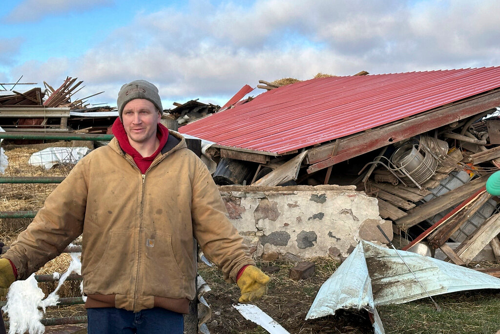 Matt Artis, 34, surveys the wreckage Friday morning, Feb. 9, 2024, after a tornado struck his farm in the Town of Porter, Wis., on Thursday evening. A line of storms and tornadoes fueld by unusually warm February weather tore across southeastern Wisconsin on Thursday.  (AP Photo/Todd Richmond)