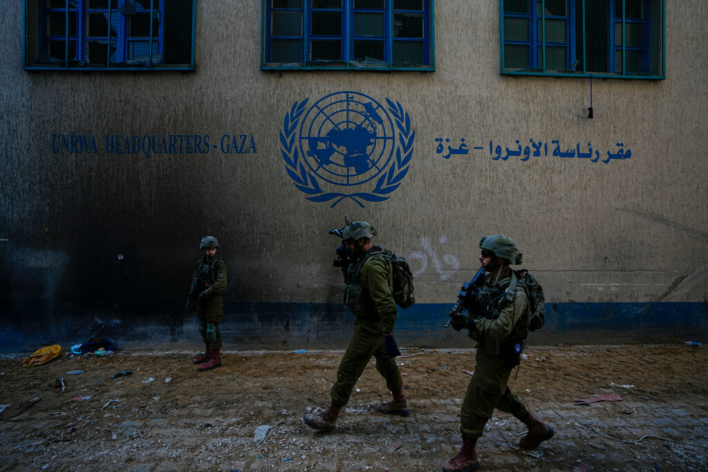 Israeli soldiers take position as they enter the UNRWA headquarter where the military discovered tunnels underneath of the U.N. agency that the military says Hamas militants used to attack its forces during a ground operation in Gaza, Thursday, Feb. 8, 2024. The Israeli military says it has discovered tunnels underneath the main headquarters of the U.N. agency for Palestinian refugees in Gaza City, alleging that Hamas militants used the space as an electrical supply room. The unveiling of the tunnels marked the latest chapter in Israel's campaign against the embattled agency, which it accuses of collaborating with Hamas. (AP Photo/Ariel Schalit)