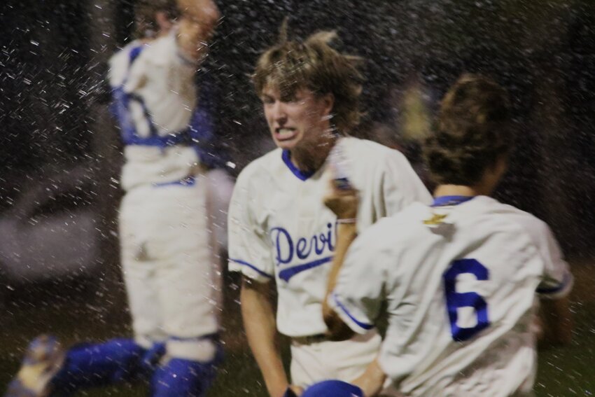 Clay High relief pitcher Ethan Mathis is sprayed by his teammates after finishing off a seventh inning rally attempt by Baker County to secure a 7-3 district title for the Blue Devils.