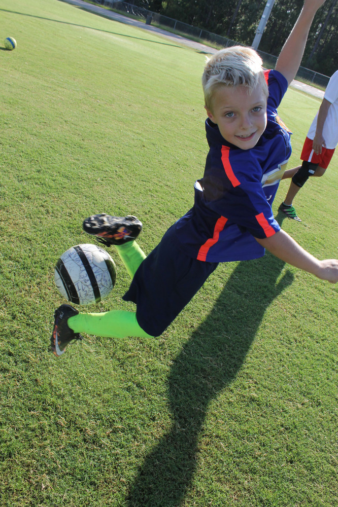 Staff photos by Randy Lefko  Fleming Island High staged the final sports camp of the summer with their youth soccer camp and Noah Ivey, 7, throws down with his best rainbow kick.