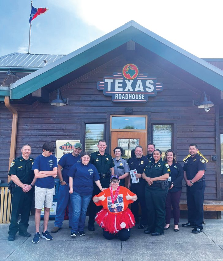 Members of the Clay County Sheriff&rsquo;s Office and Orange Park Police Department join athletes and supporters of the Clay County Special Olympics team after they collected $12,009 in three nights at Texas Roadhouse during its annual Top-A-Cop program. The money will send county athletes to the Florida Special Olympics Games at Walt Disney World in May.
