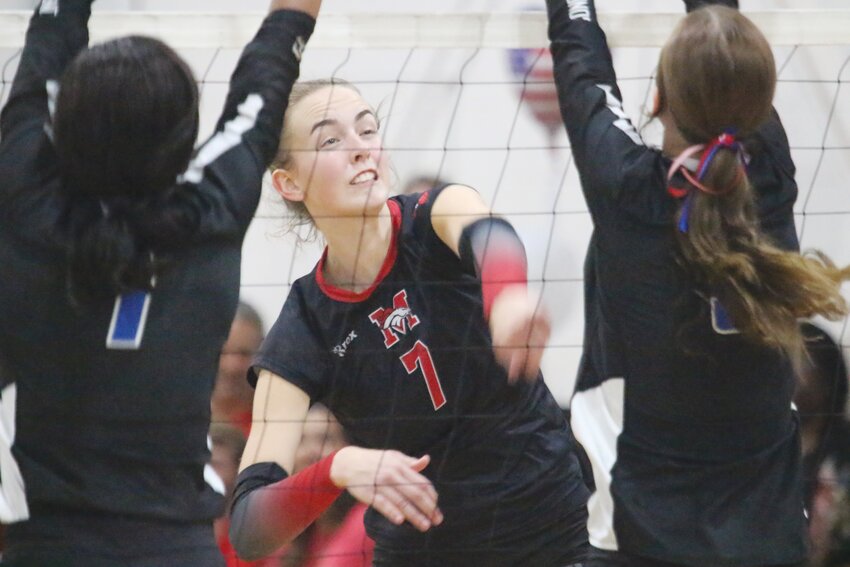 Middleburg High lefty hitter Brooke Forkum tries to slice between two Trinity Christian blockers in tough action in a loud gym.