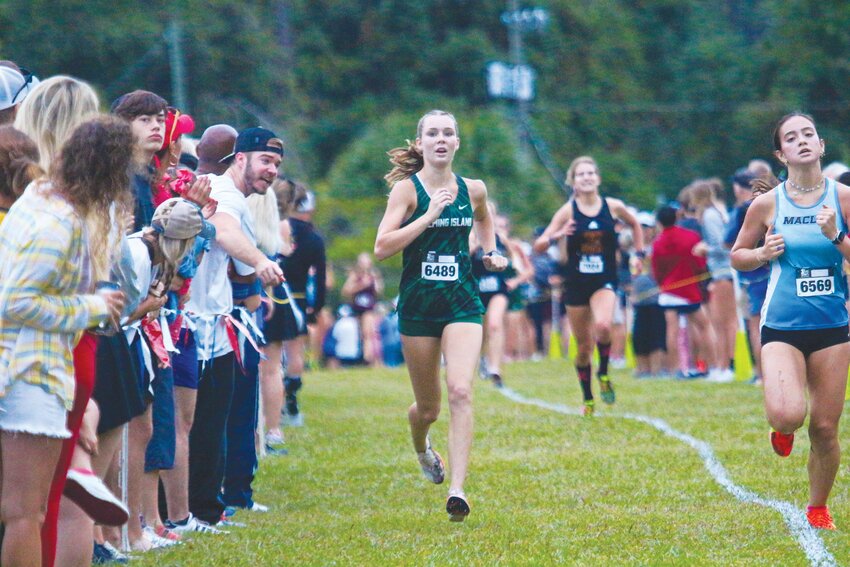 Fleming Island senior cross country runner Allie Knotts heads toward finish line of New World Fall Classic in Jacksonville with big brother Luke Knott pointing the way.