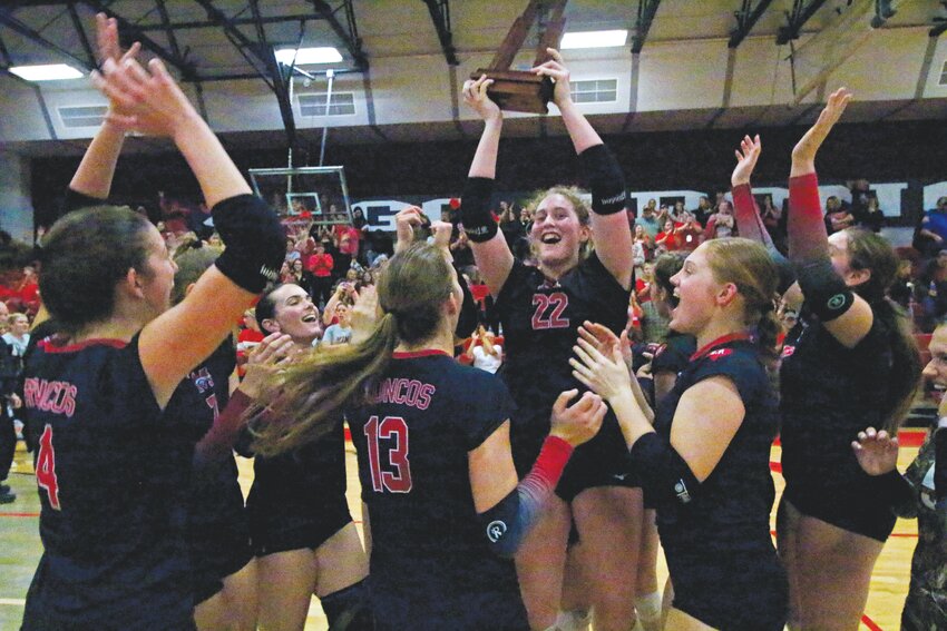 Middleburg High setter Olivia Callipo holds the district championship trophy after her Lady Broncos beat Ridgeview 3-0 on Thursday. Broncos, Panthers and St. Johns Country Day School all advanced into region playoffs.
