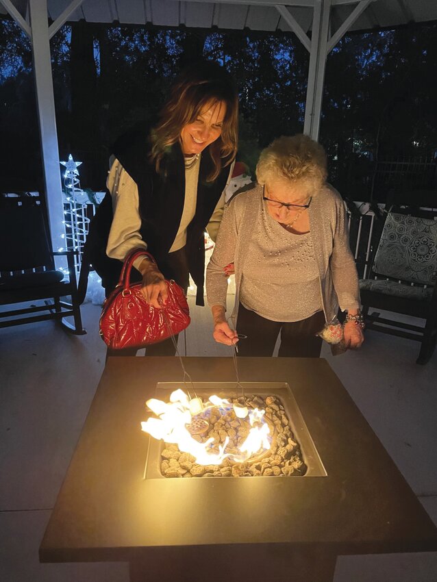 Residents and their families roast marshmallows for s&rsquo;mores over the fire.