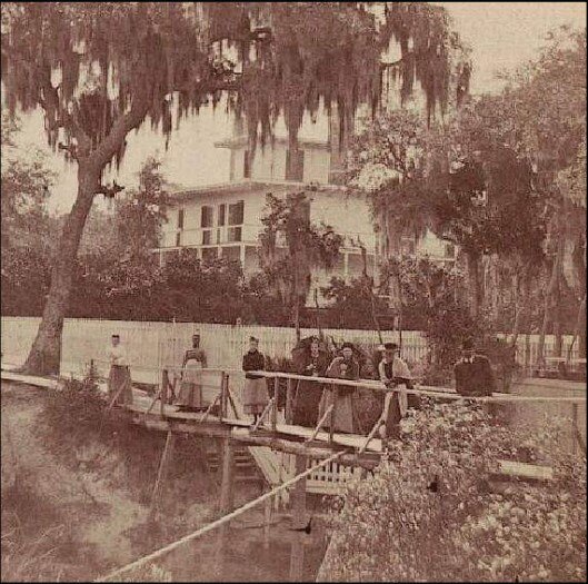 Tourists crossing the spring run. The Schulz House is seen in the background &ndash; a home that still stands today across from the spring.