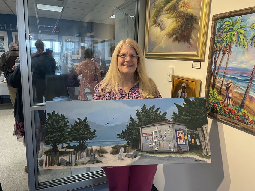 Cynthia Royce Smith takes down &ldquo;Fat Boy&rsquo;s Seafood&rdquo; from the wall and prepares to take the piece home. Her painting and the paintings of many others were proudly displayed at the Sky Gallery at the Jacksonville International Airport.