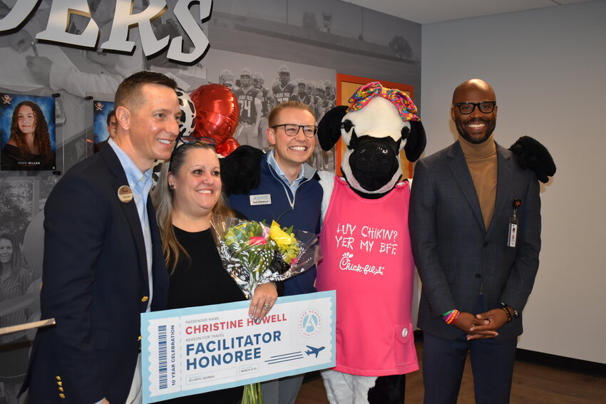 Wells Road Chick-fil-A operator Craig Phillips from left joined Christine Howell, ADDO&rsquo;s Jack Roberson, the Chick-fil-A Cow and Orange Park High Principal Ivin Gunder during Thursday&rsquo;s surprise announcement. Howell earned one of 10 national Facilitator Honorees for the Chick-fil-A Leader Academy.