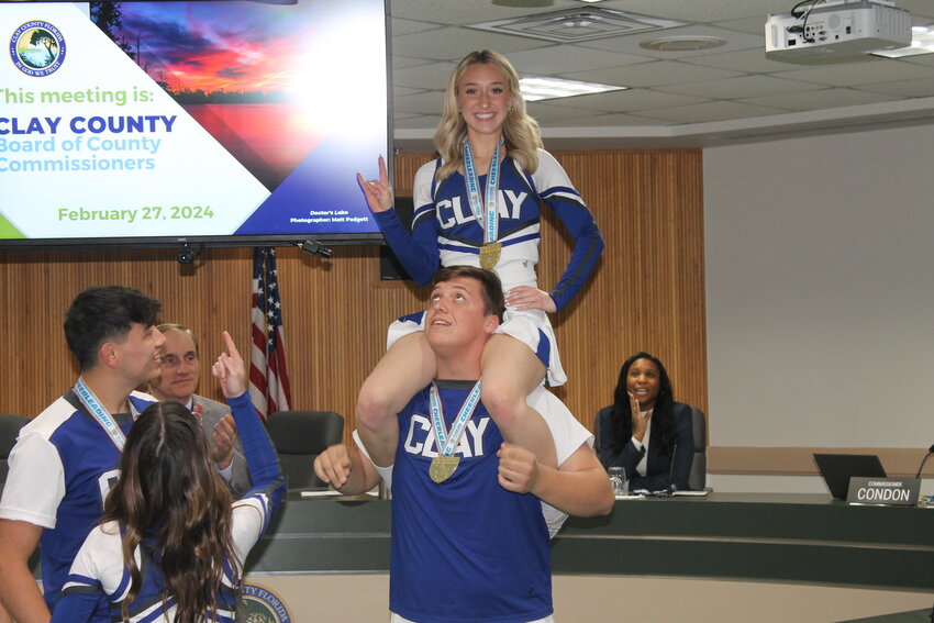 The competitive cheerleading team celebrated with a stunt following the proclamation.
