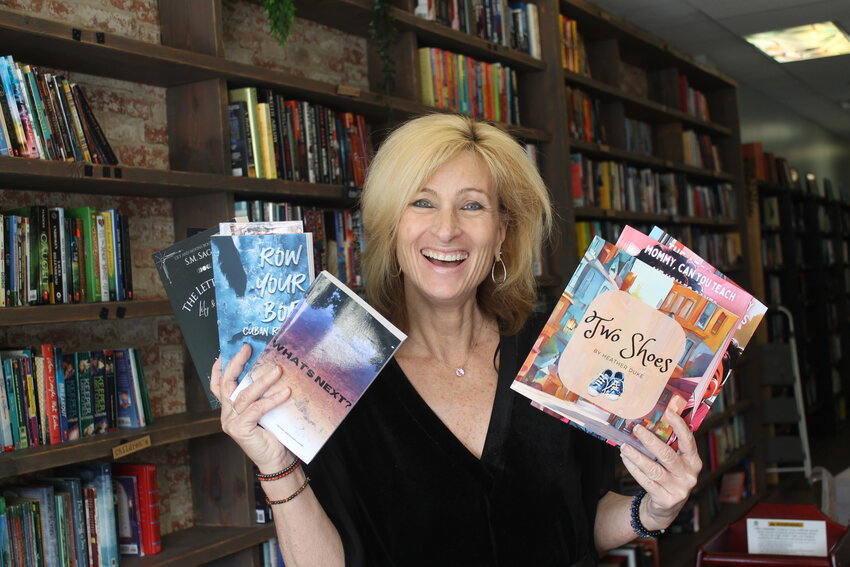 Avid reader Tanya Lea proudly displays her new additions to her bookshelf.