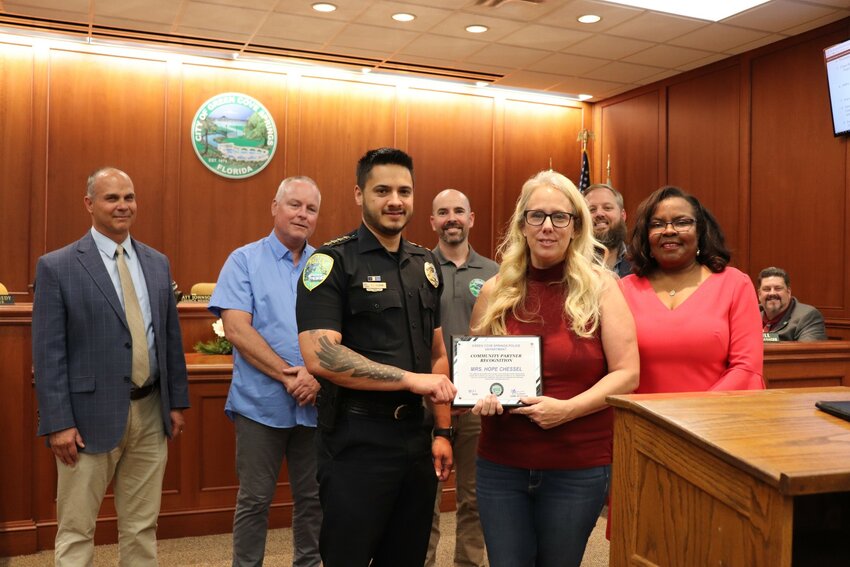 Green Cove Springs Police Chief E.J. Guzman hands a City proclamation to Hope Chessel during Tuesday's City Council meeting for her tireless volunteer efforts to help his department and the city.