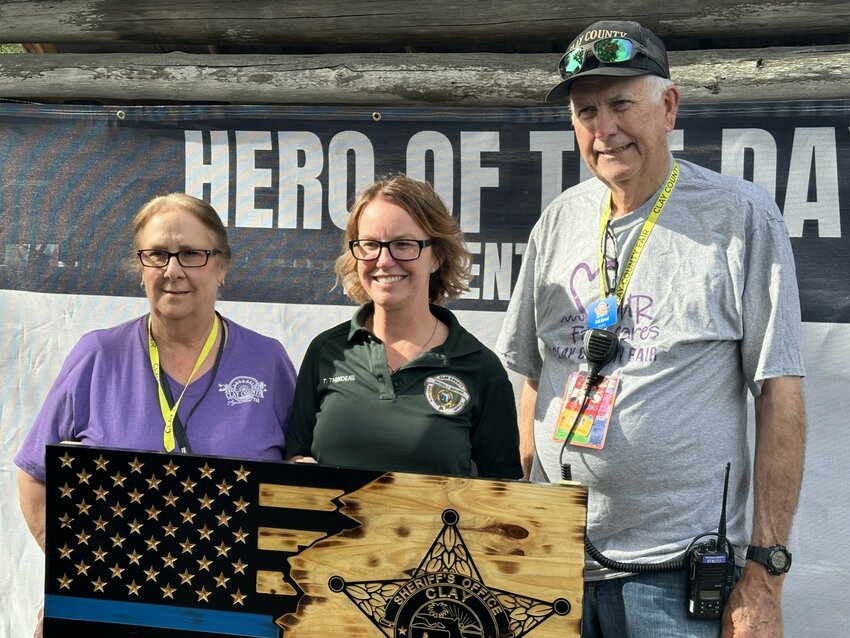 Clay County Fair Association Office Manager Karen Brown, left. presents Clay County Sheriff's Office Crime Scene Tech Tiffany Thibideau while they were joined by Fair Vice Chair Bill Elrod.