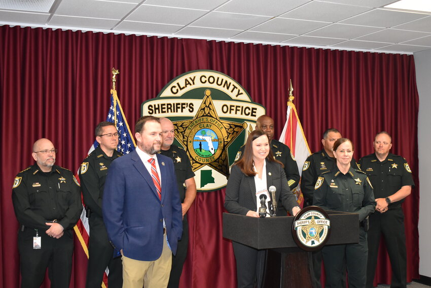 Florida Attorney General Ashley Moody is flanked by members of the Clay County Sheriff's Office and Judson Sapp of Signal 35.