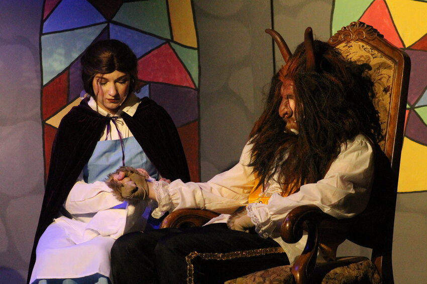 Sarah Crouch as Belle sitting beside Aaron Burdick as the Beast