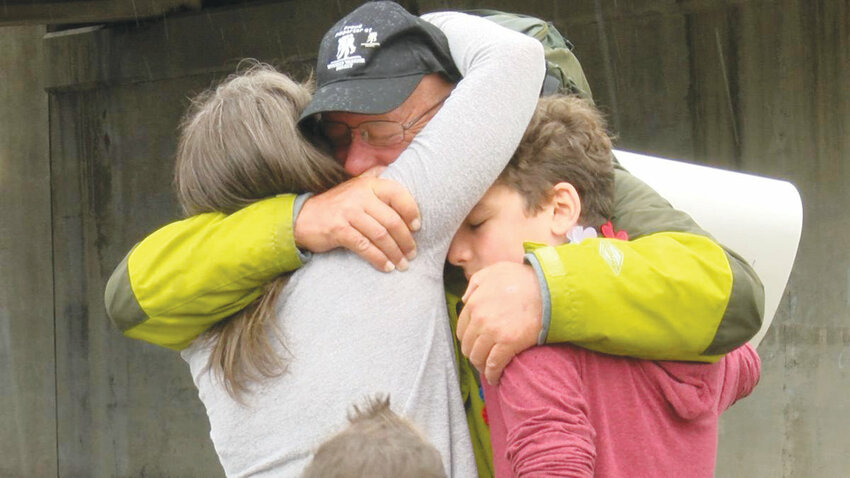 Ken Brock is hugged by his daughter, Alexis, after he finished his 2,650-mile journey. He arrived five years ago, just a few days before the Fourth of July.