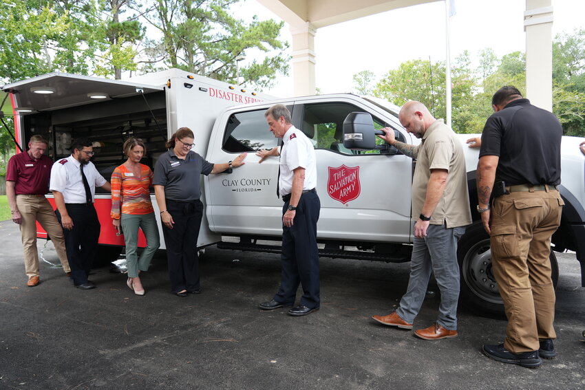 Emergency management, Lilly Endowment and Salvation Army officials pray after receiving the first of 16 trucks donated by the Lilly Endowment.