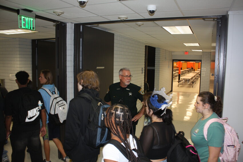 School Resource Officer Rob Troxel monitors students at Orange Park High on Tuesday as they change class on the first day of school.