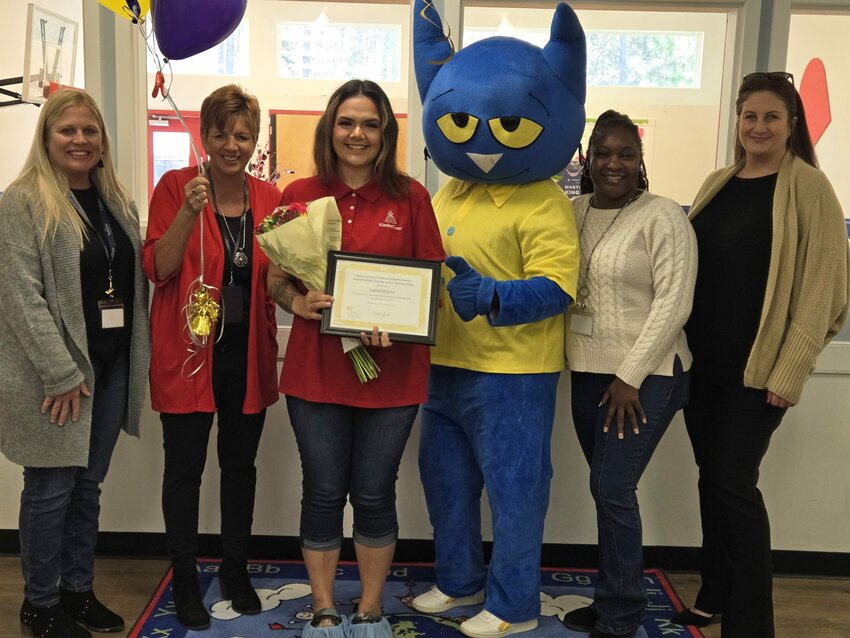 Isabel Molina, center, was surprised at KinderCare in Oakleaf when she learned she was recognized by the Early Learning Coalition of North Florida as its Infant/Toddler Teacher of the Year.