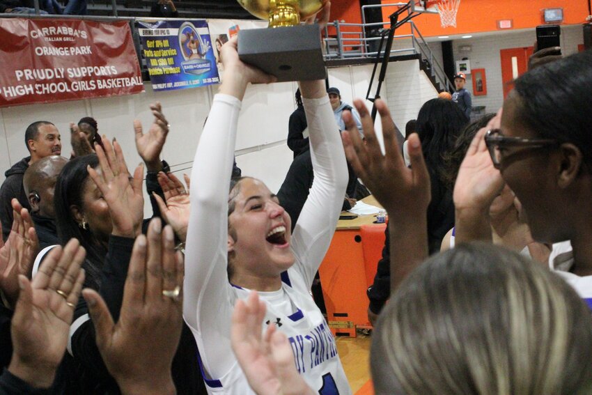 Ridgeview High senior guard Emma Rayes holds up Clay County Cup first place trophy after Panthers defeated Orange Park 51-45 in championship game.